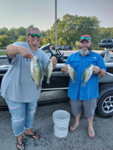 Anglers holding their catch beside the fishing boat